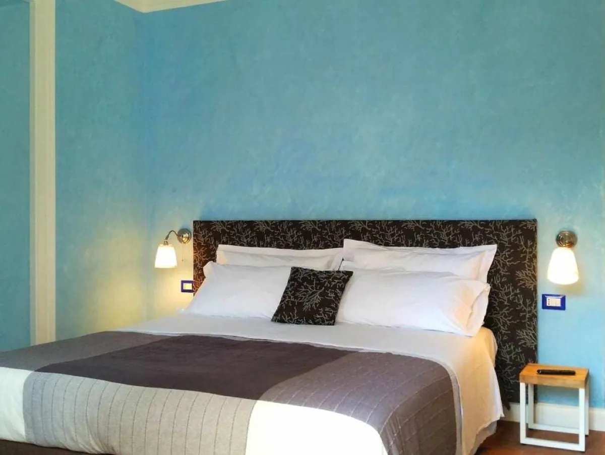 Camera deluxe con parete blu, zona notte e zona giorno separate