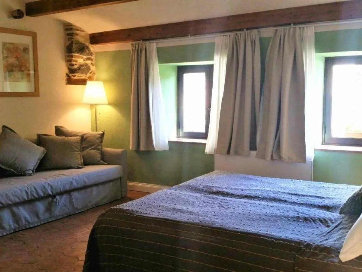 Camera familiare con parete verde, letto matrimoniale e zona relax